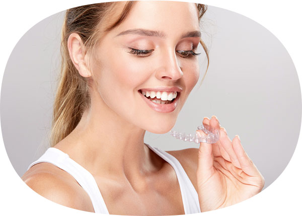 girl-smiling-while-holding-invisalign-aligner